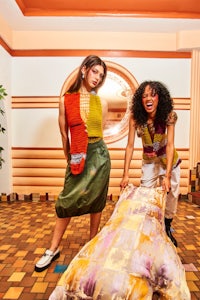 two women standing on a rug in a room