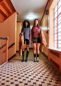 two women standing in a hallway with teddy bears